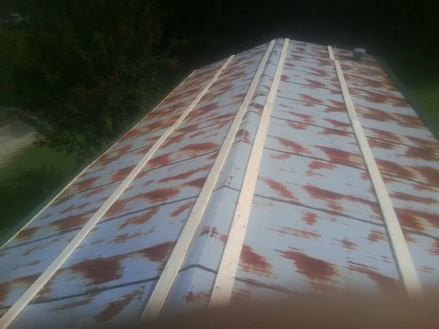 Rusted metal roof panels with new wood purlins before replacement — Storm Damage Roof Repair in Richland by Roofing Brothers